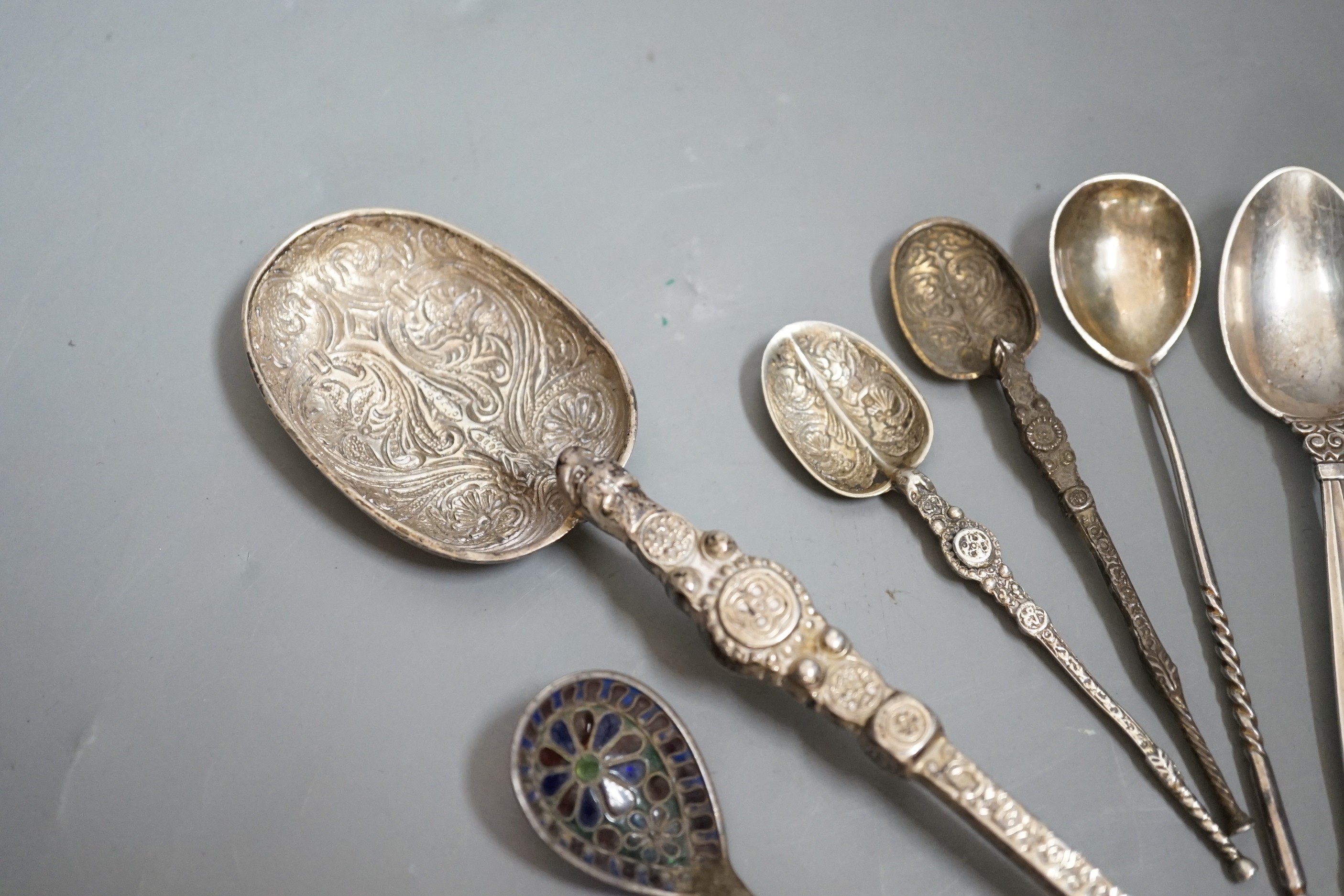 A 1930's silver replica of The Anointing spoon, 24.7cm, two similar smaller spoons, a Georg Jensen spoon, an Austro-Hungarian white metal and plique a jour spoon and a Russian tea spoon.